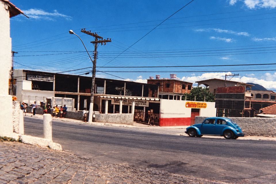 Foto de 1995: a loja vista do outro lado da rua, com um Fusca azul na frente